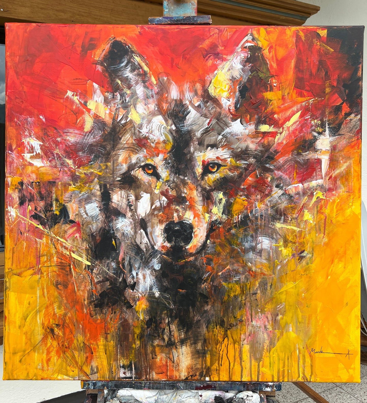 Abstract painting on an easel with a palette and brush in the background