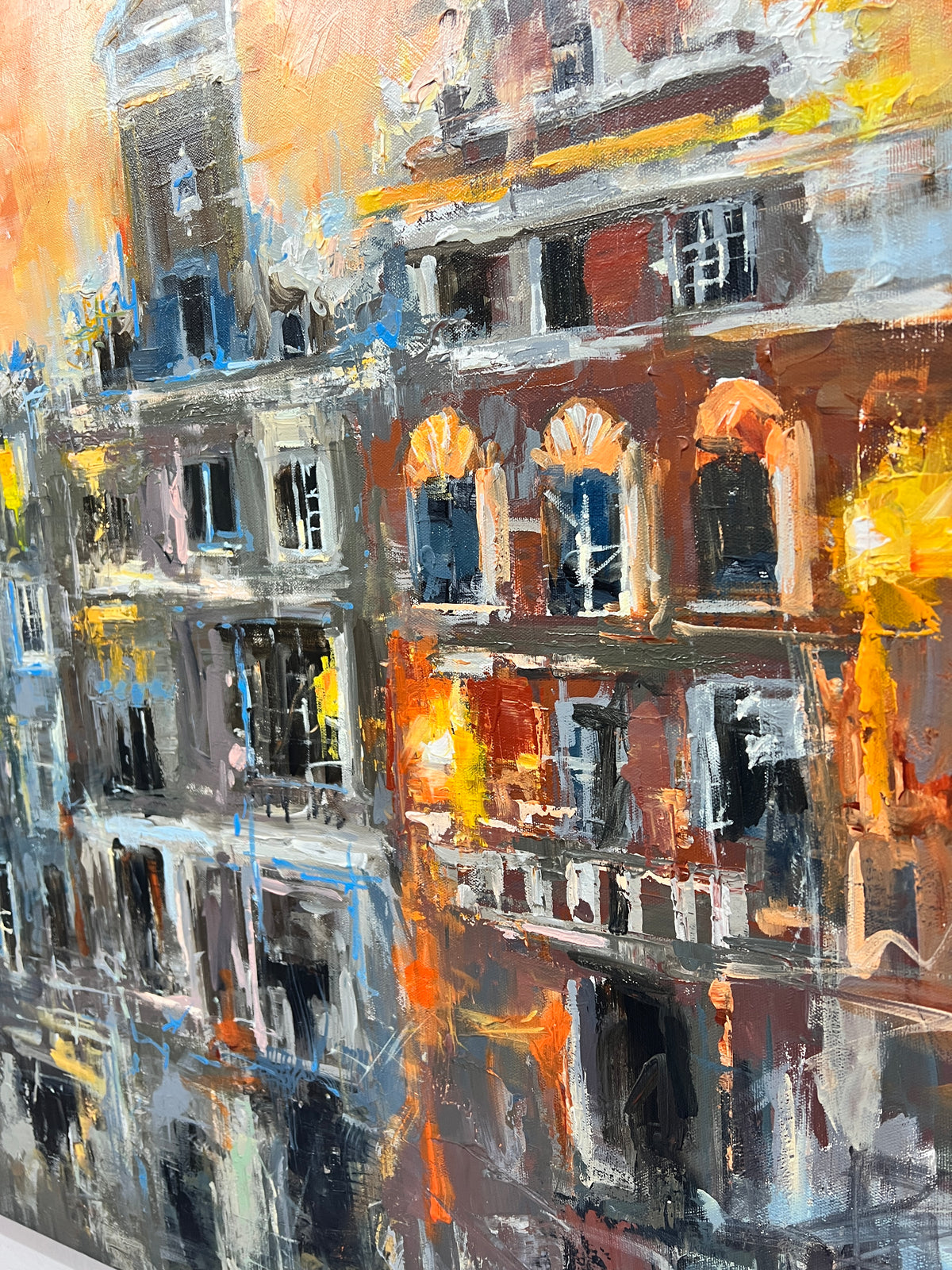 An impressionistic painting of urban apartment buildings with expressive brushstrokes in orange, yellow, gray, black, white, and blue.