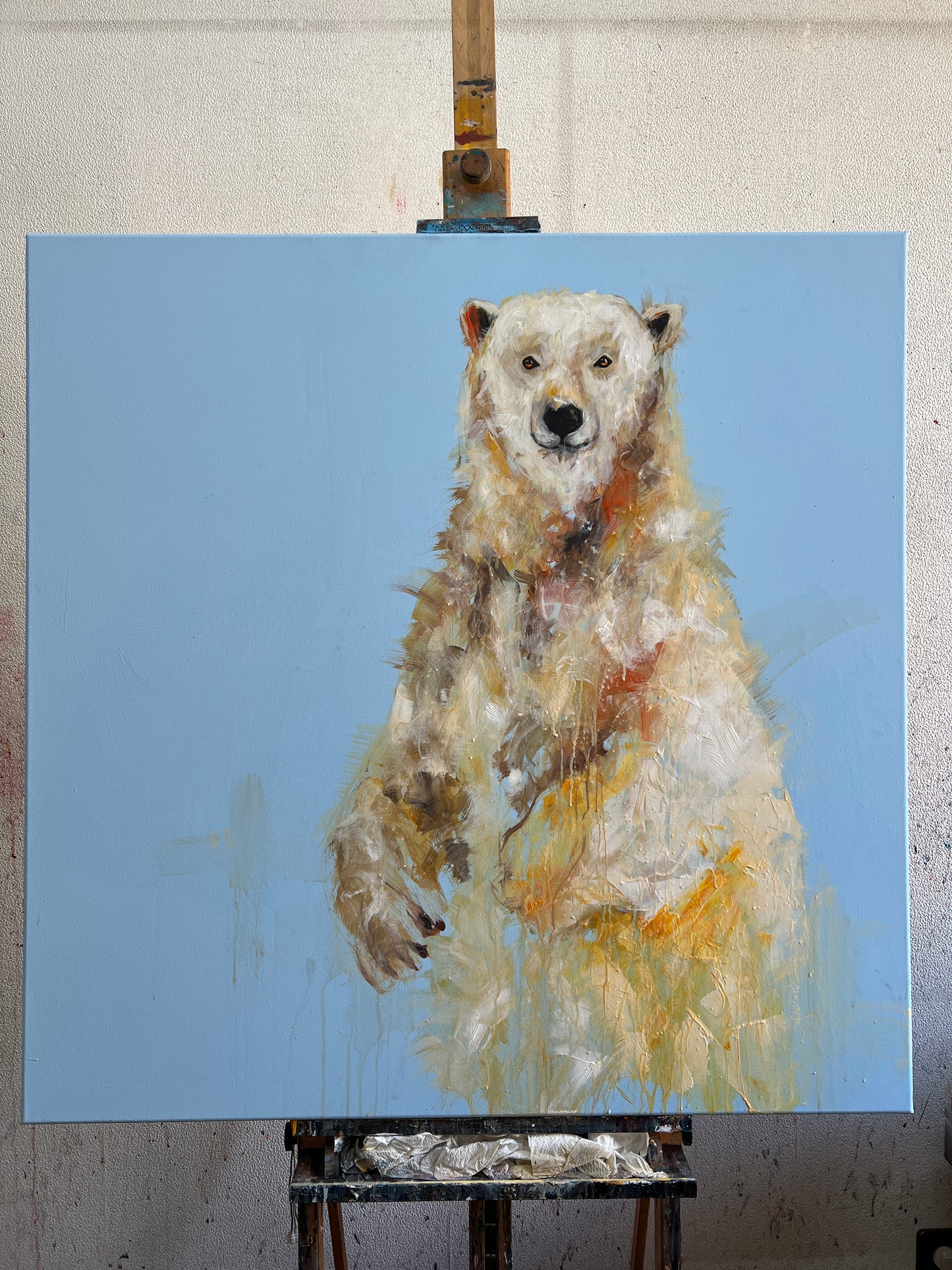 Painting of a bear on an easel with a blue background